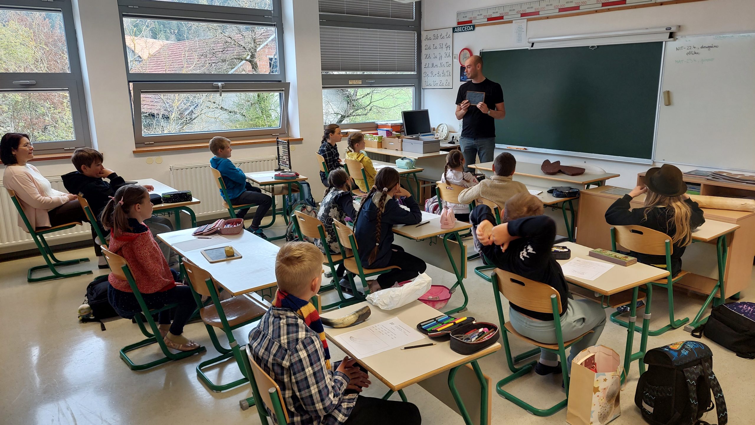 Učenci pri delavnici Raziskujmo muzejske predmete